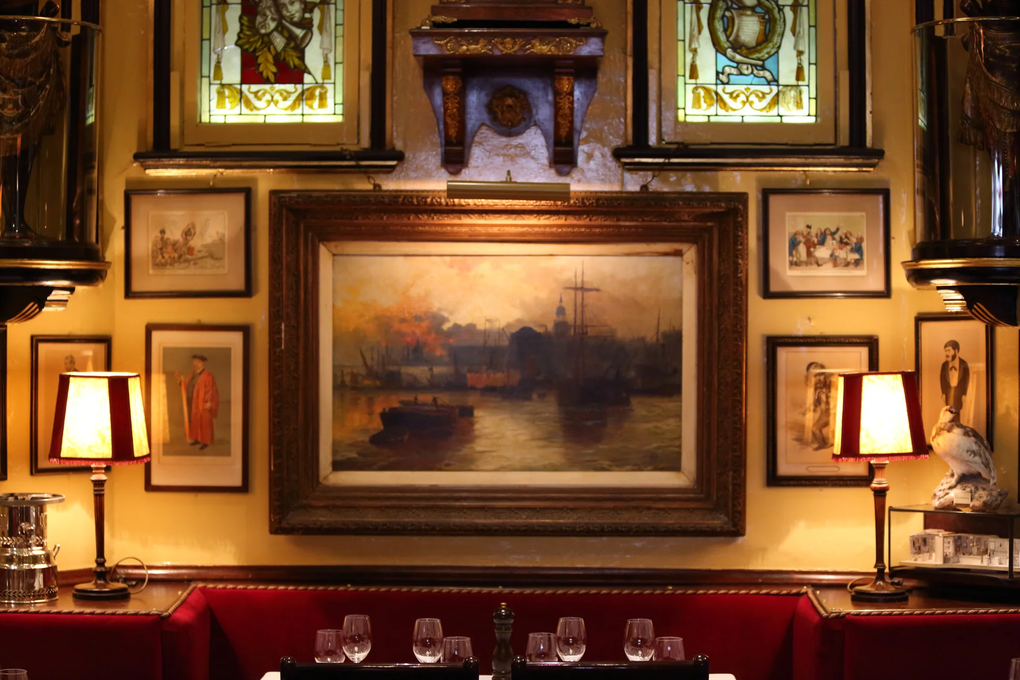A harbour painting in a gilt frame above the banquettes at Rules on Maiden Lane