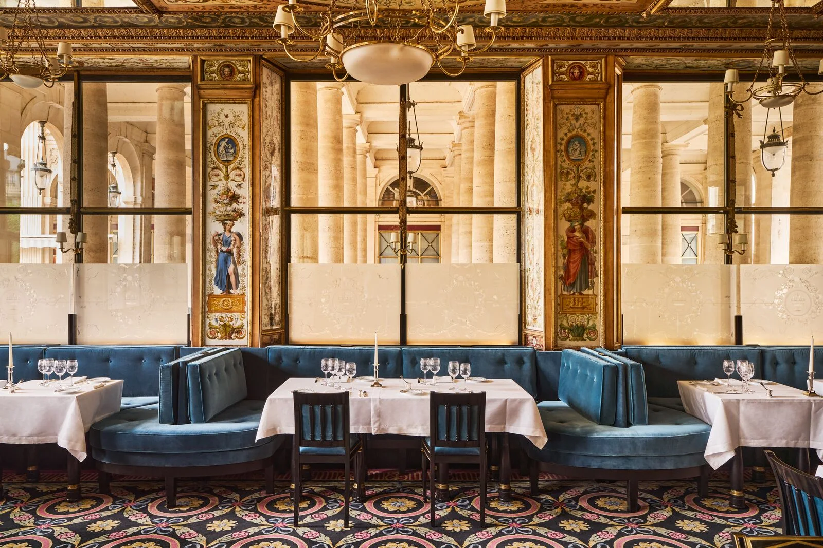 Blue banquettes and painted panels at Le Grand Véfour, with the Palais-Royal arcade beyond